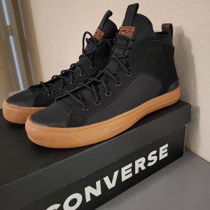 Black and warm tan Converse high top shoes.